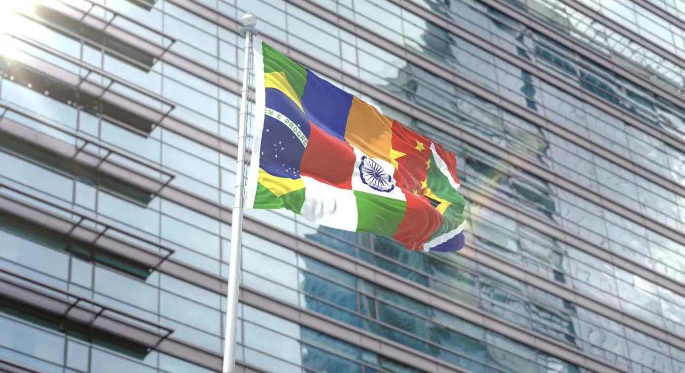 BRICS nations flag against modern building backdrop.