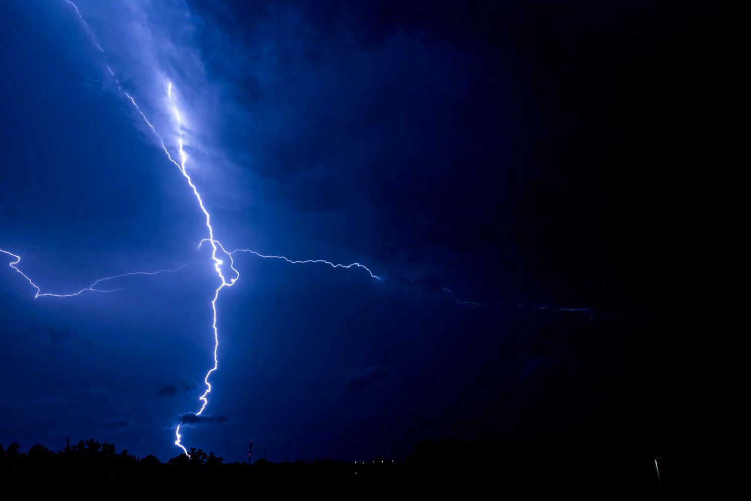 Bright lightning bolt in dark sky.