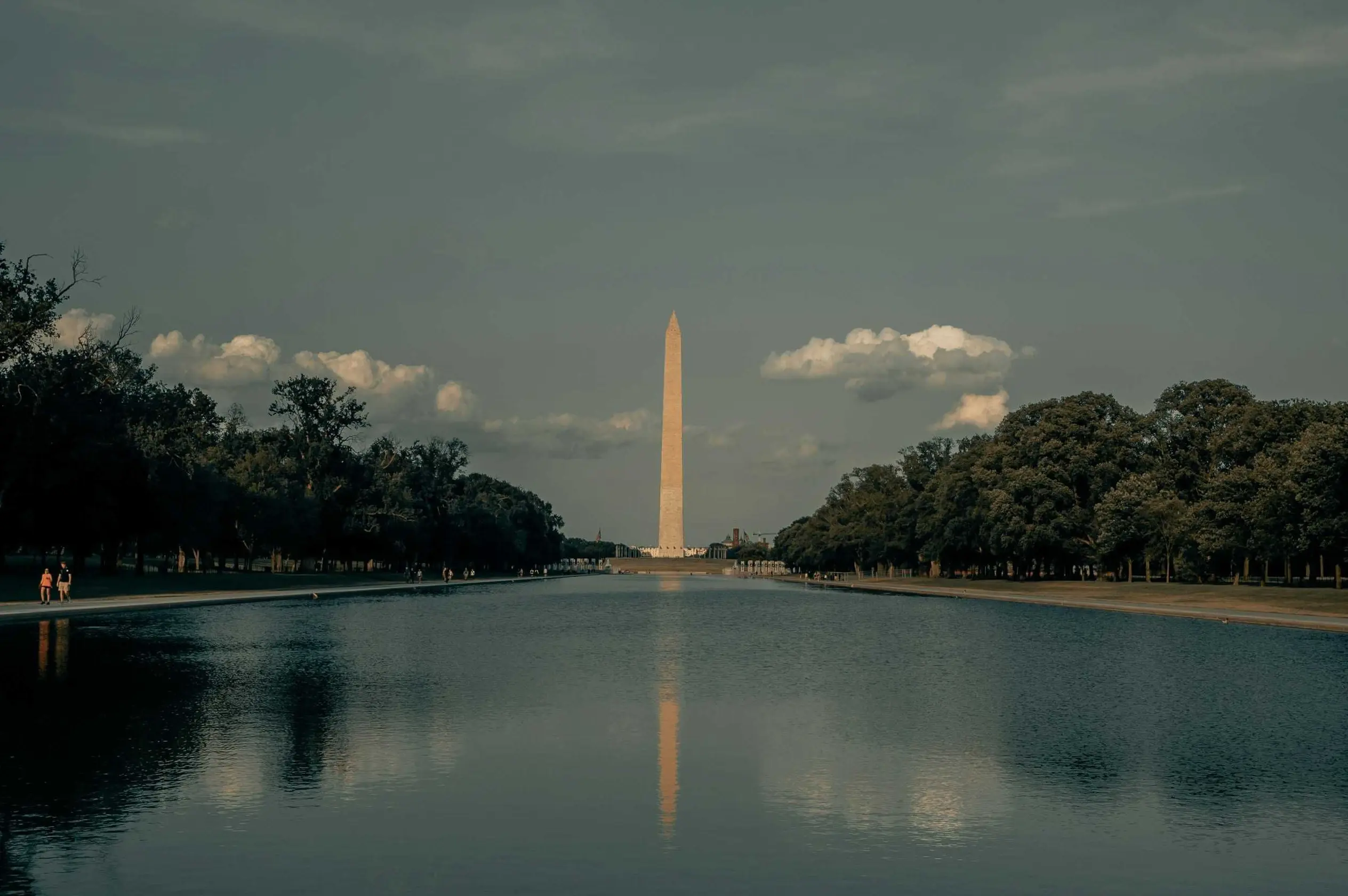 Washington Monument reflected in water, cloudy sky