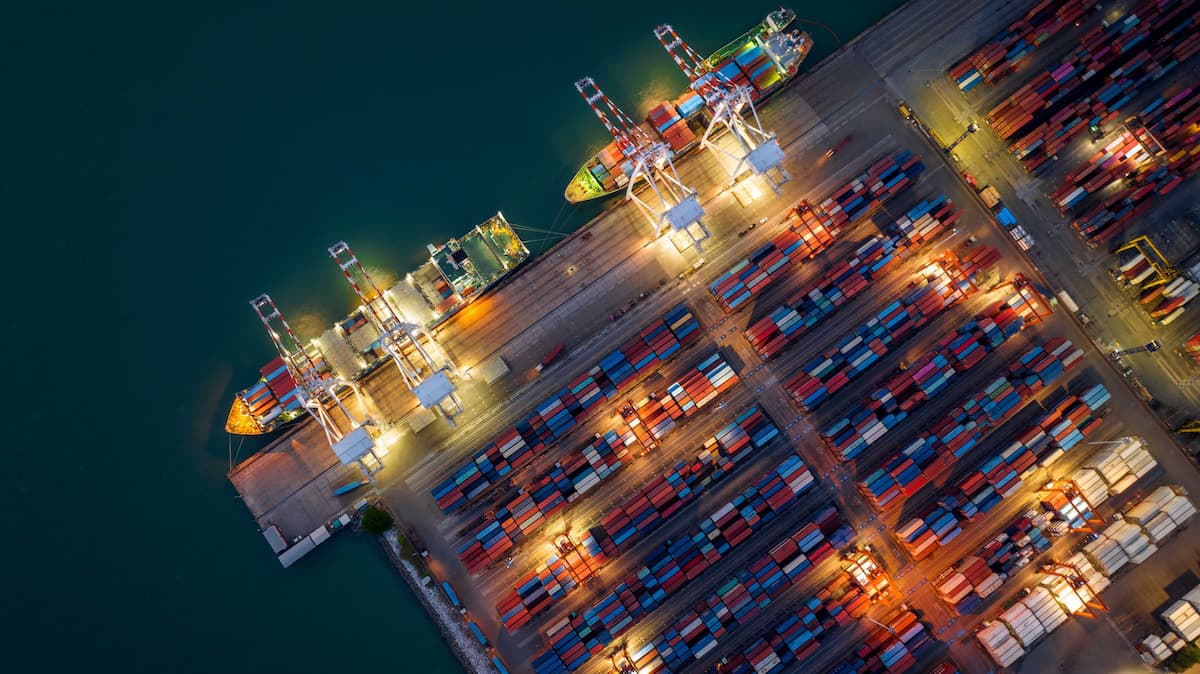 Aerial view of illuminated shipping port at night.